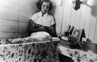 image of woman on bunk with pensive look and photo of man beside her